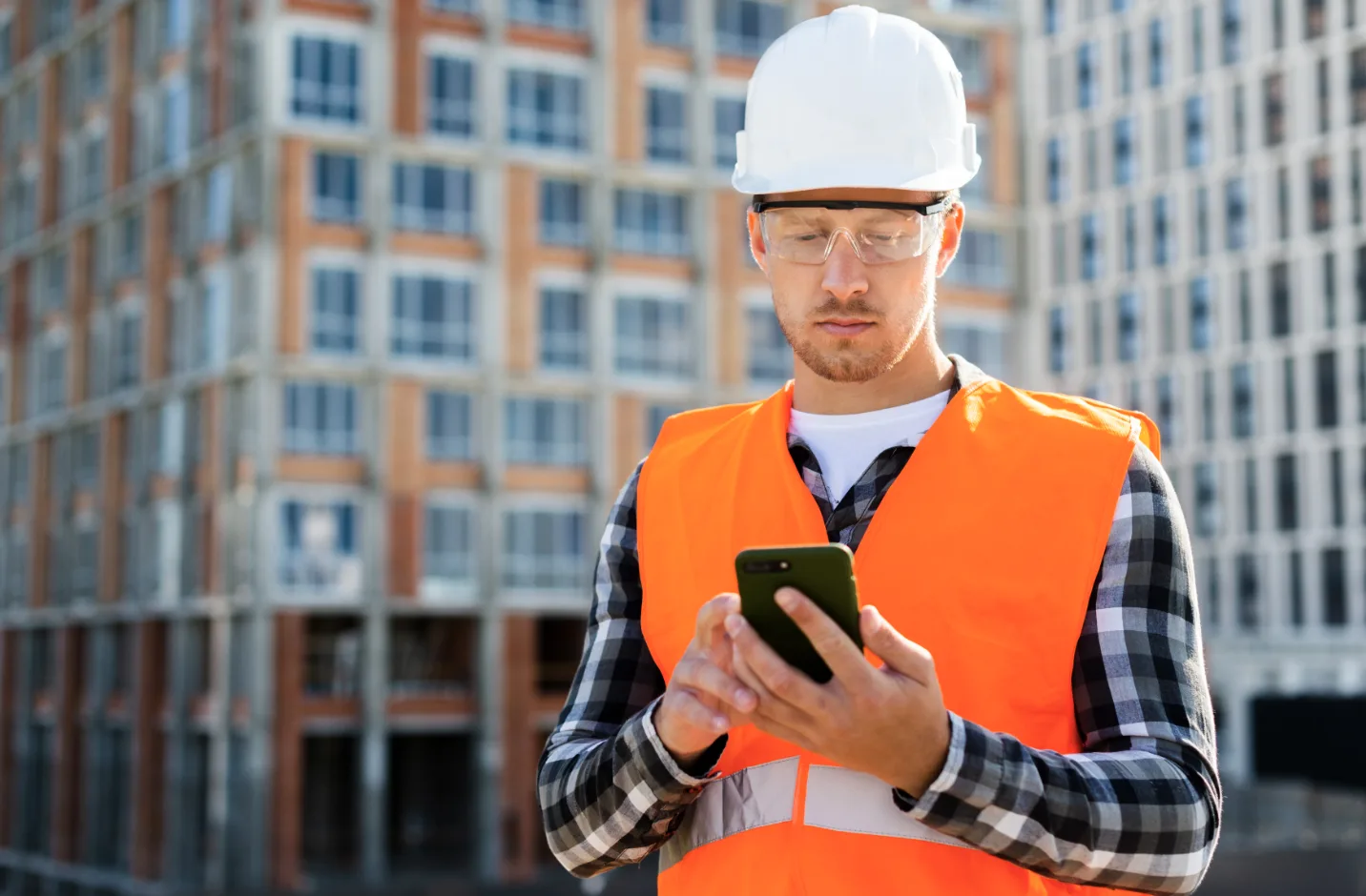 Operaio che gestisce il cantiere da smartphone