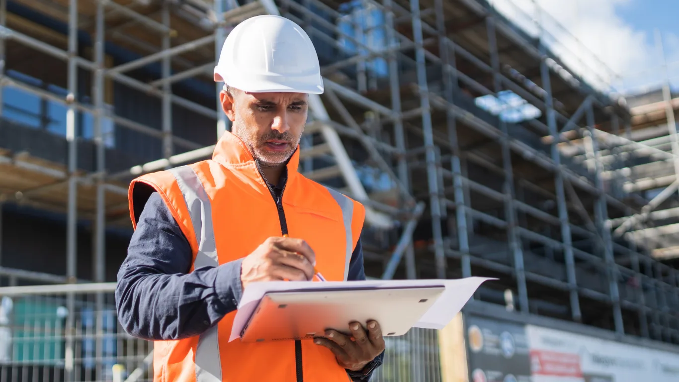 Operaio in cantiere che firma un documento