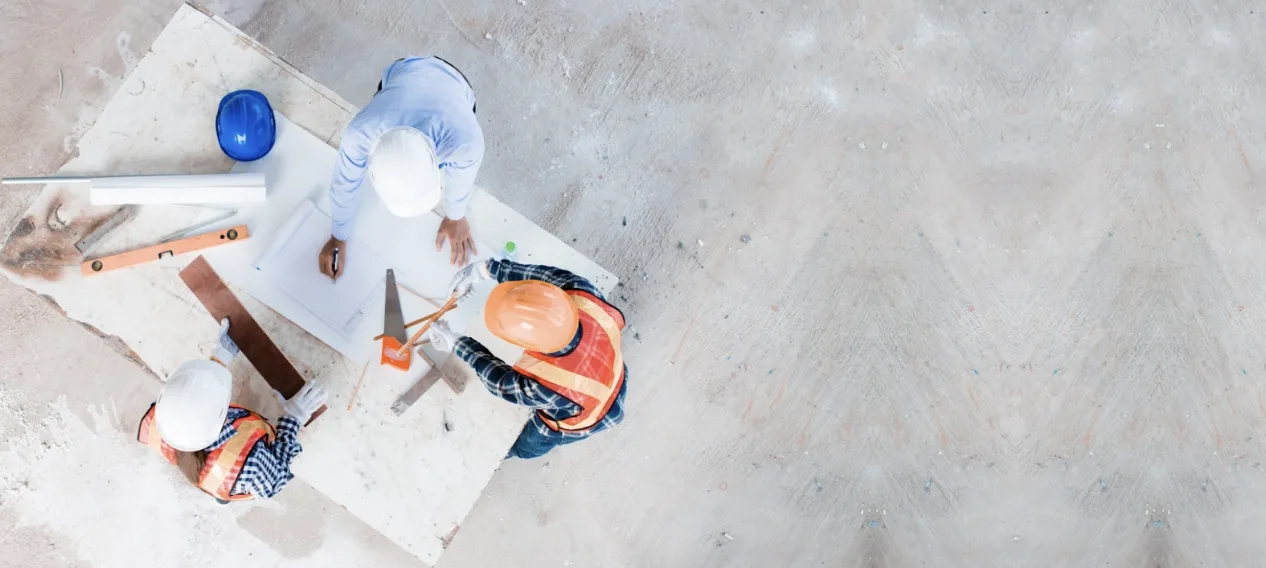 Progettisti in cantiere lavorano su carte di progetto