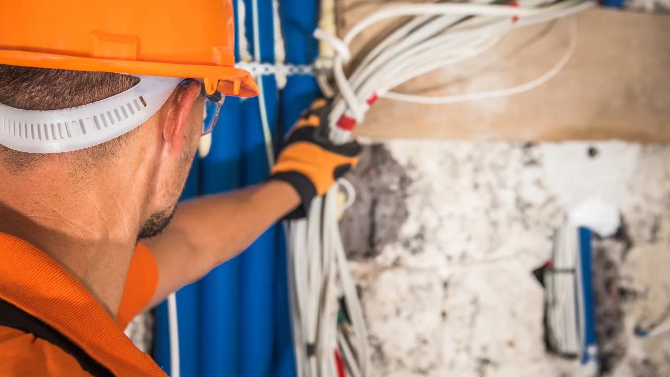 Operaio installa cavi in cantiere